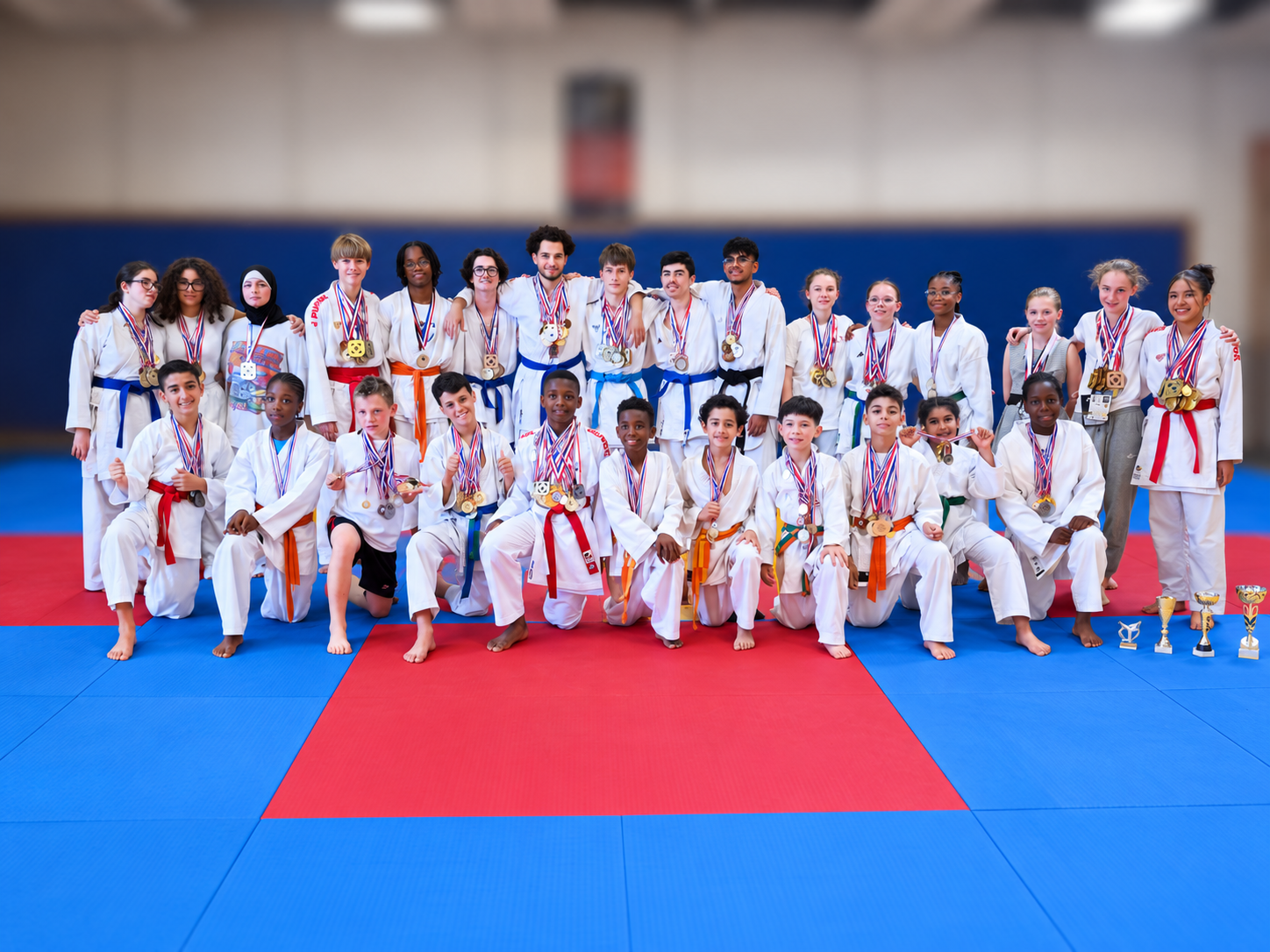Le groupe KTE médaillé sur un tatami bleu et rouge